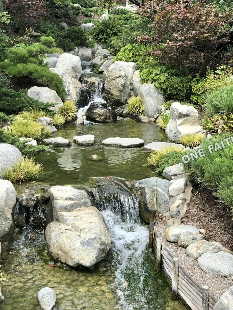 A quiet garden with stones and flowing water.