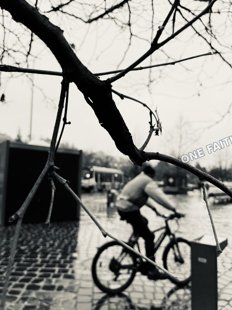 A cyclist passing through a city street in winter.