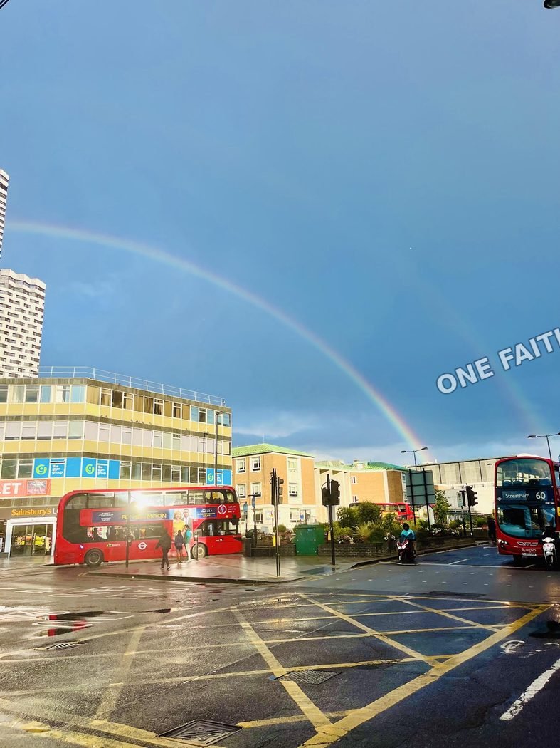 A rainbow over a city street after rain.