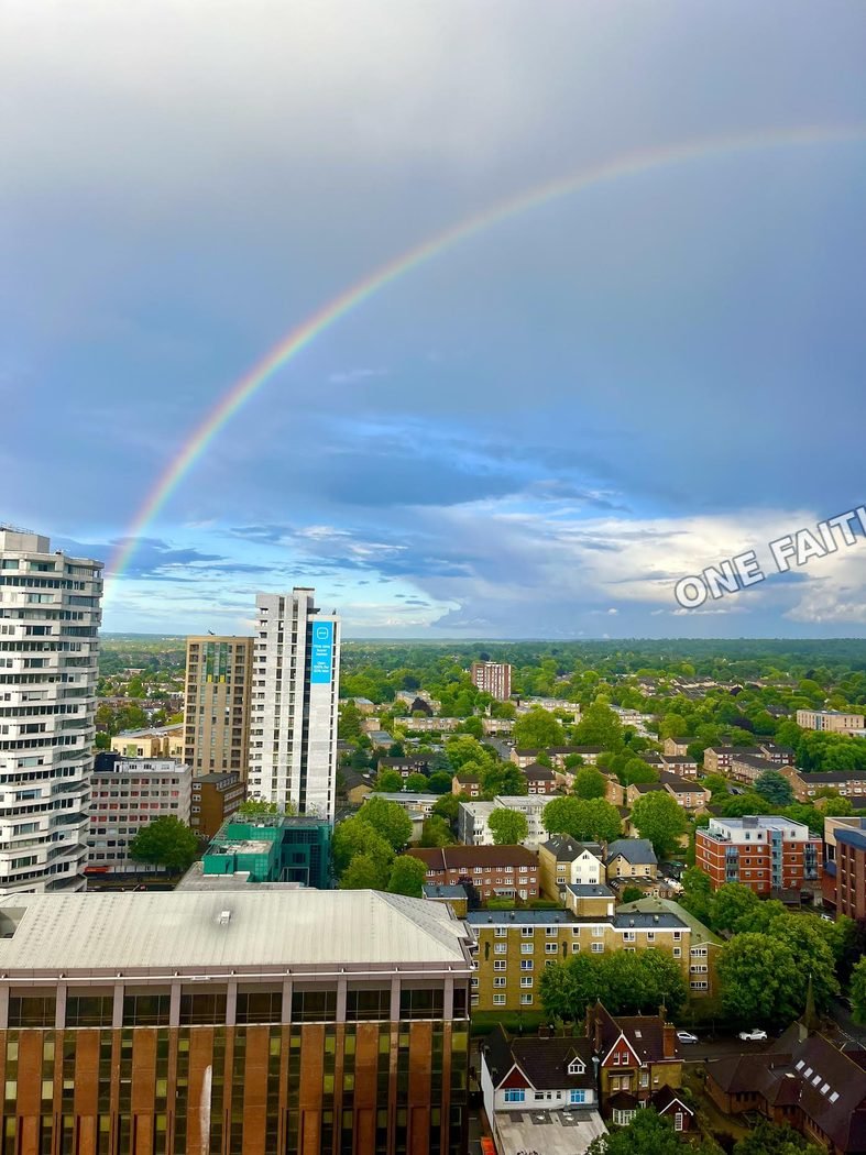 A rainbow stretching above a town.